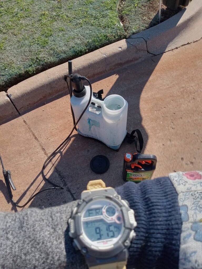 A person preparing a pump sprayer for lawn treatment, showing services by A & A Lawn Care Service LLC in Edmond, OK.