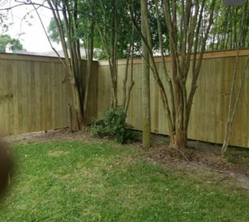 A pressure-treated wood fence enclosing a backyard, installed by Weber Fence LLC in Baton Rouge, LA.