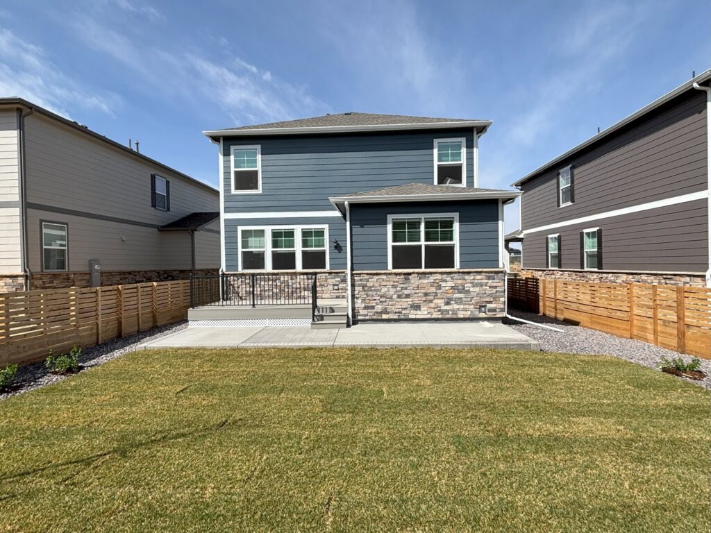 A pristine, newly installed backyard lawn next to a modern patio by The Fisherman Landscaping LLC in Westminster, CO.