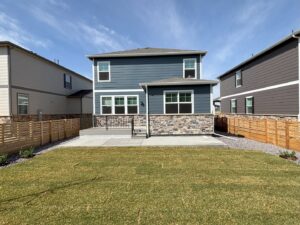 A pristine, newly installed backyard lawn next to a modern patio by The Fisherman Landscaping LLC in Westminster, CO.