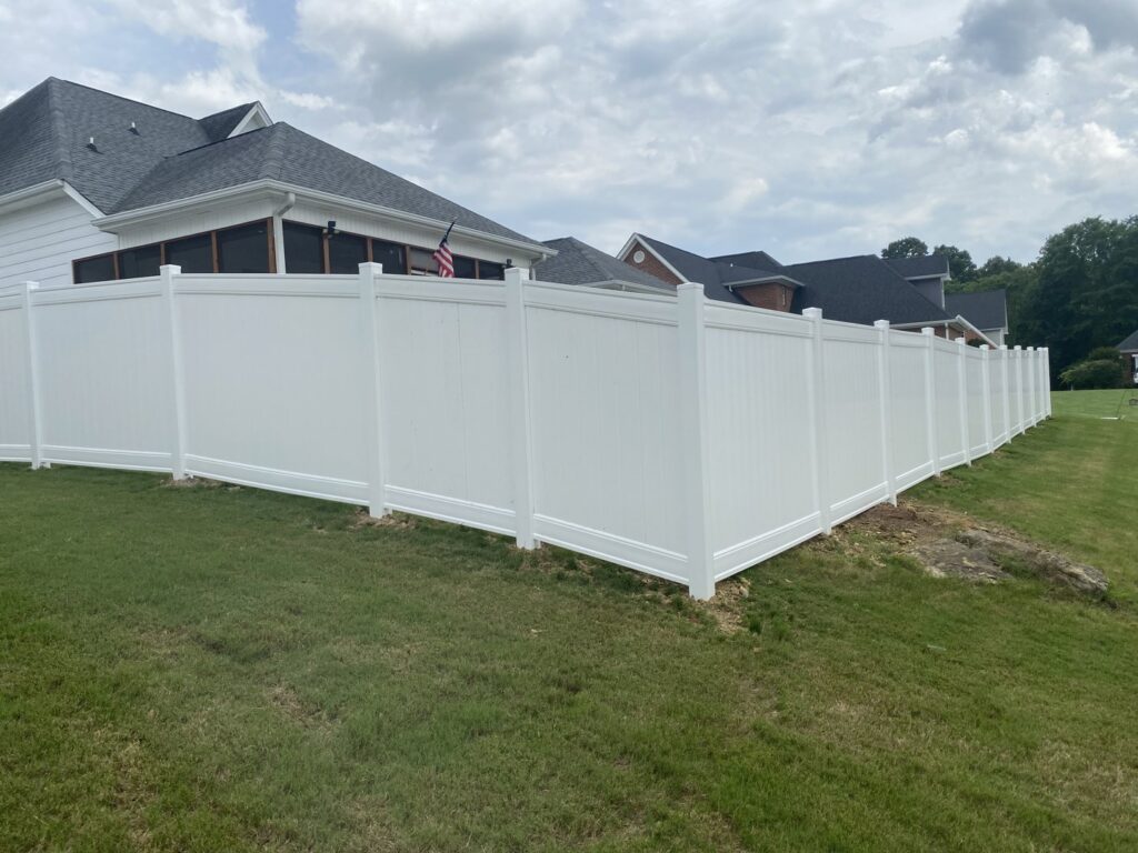 A pristine white vinyl privacy fence installed along a residential property line by Holmes Fence Company in Chattanooga, TN.