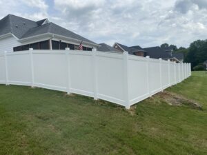 A pristine white vinyl privacy fence installed along a residential property line by Holmes Fence Company in Chattanooga, TN.
