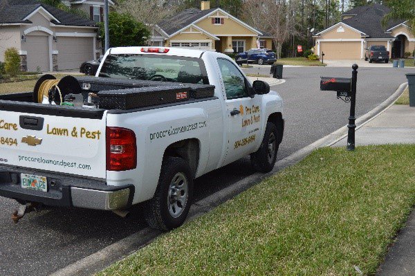 A Pro Care Lawn and Pest service truck parked in a residential neighborhood in Jacksonville, FL.