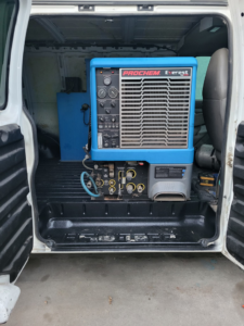 A Prochem Everest truckmount carpet cleaning machine installed in a service van for Delmac Products Truckmount Service in Bakersfield, CA.