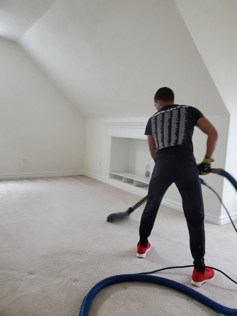 A professional carpet cleaner operating equipment on a light-colored carpet for Kingdom Kleen in Portsmouth, VA.
