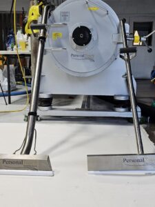 Professional carpet cleaning wands with business branding in front of a large rug cleaning machine at Personal Touch Carpet Cleaning in Chicago, IL.