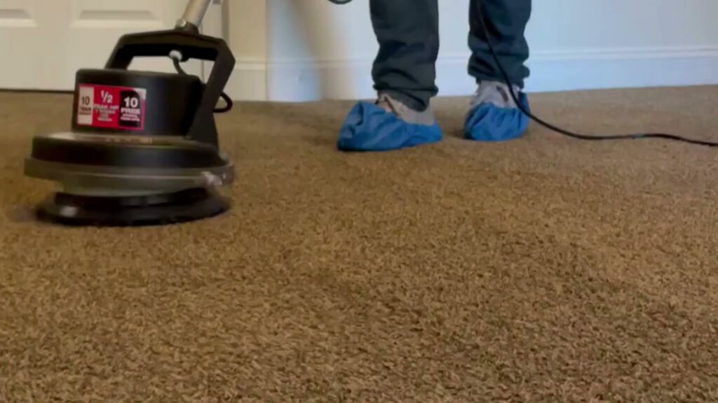 A professional operating a rotary carpet cleaning machine for Express Cleaning in Lowell, MA