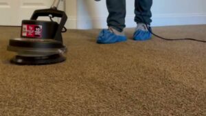 A professional operating a rotary carpet cleaning machine for Express Cleaning in Lowell, MA