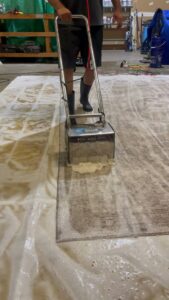 A technician from BeClean in Charlotte, NC, performing professional carpet cleaning with a specialized machine.