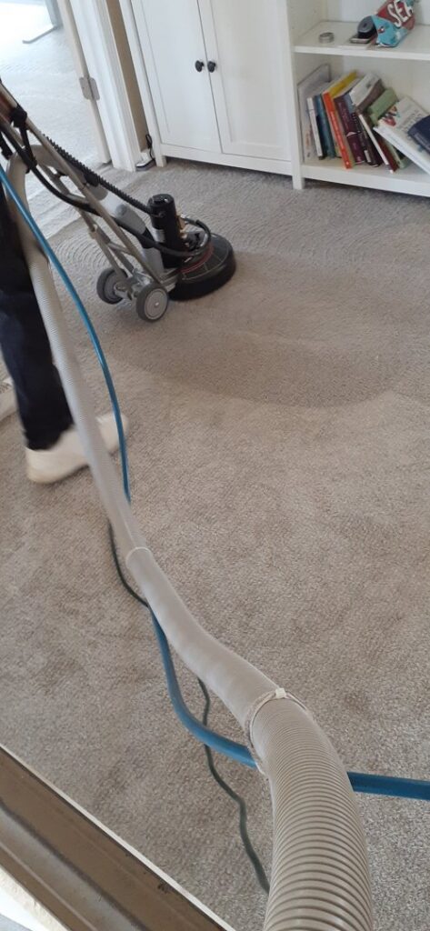 A professional carpet cleaning machine being operated on a light-colored carpet by El Paso Carpet Care in El Paso, TX.
