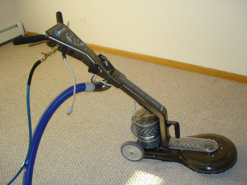 A professional carpet cleaning machine with attached hoses on a light-colored carpet by Magic Touch Carpet Cleaning in Chicago, IL.