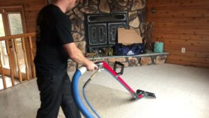A professional performing carpet cleaning with a specialized machine at C&R's Carpet Cleaning in Ellsworth, ME.