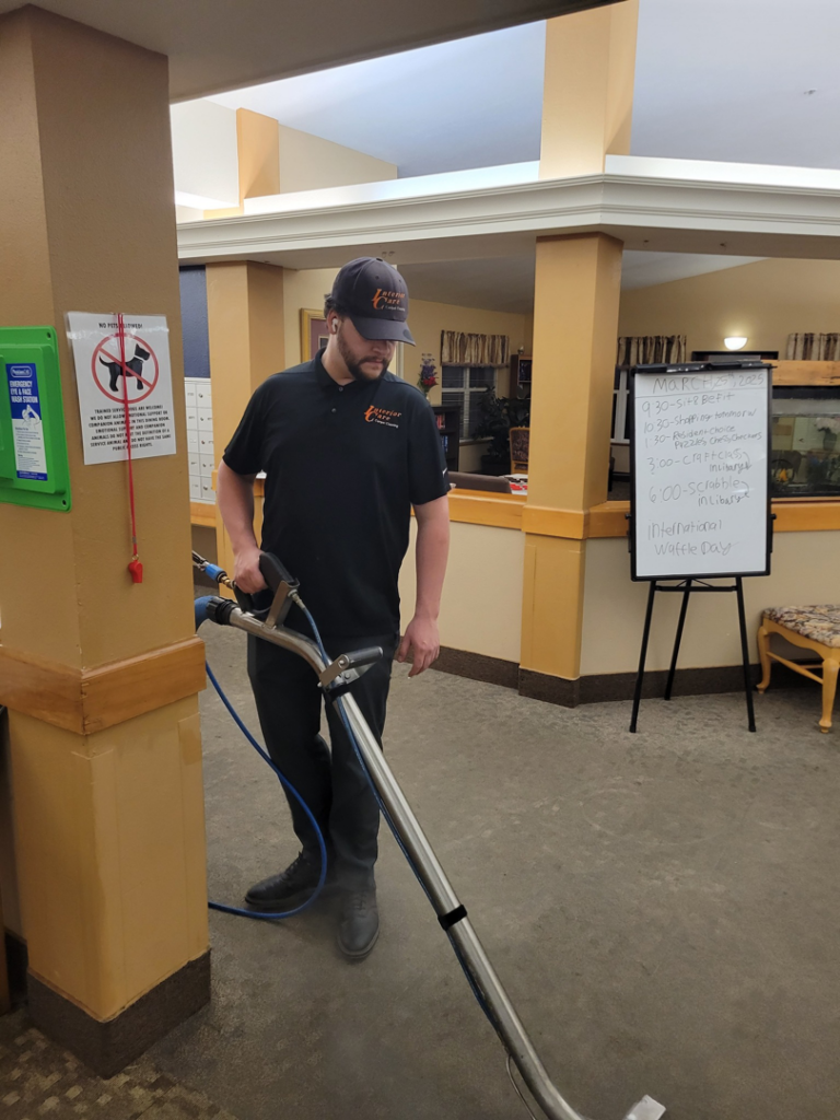 A professional from Interior Care Carpet Cleaning performing a carpet cleaning service with a wand in Bend, OR.
