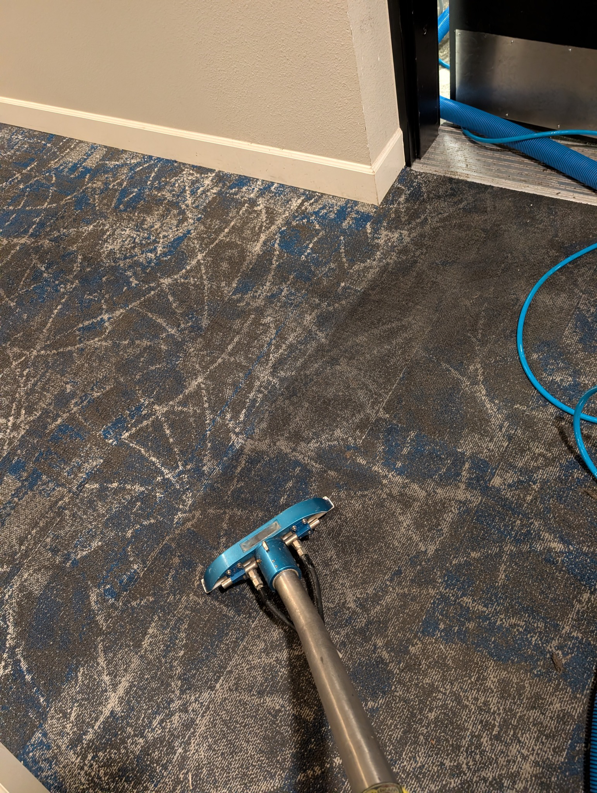 A professional carpet cleaning tool in use on a patterned carpet by Premier Carpet Cleaning in Colorado Springs, CO.