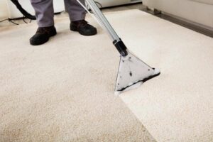 A professional carpet cleaning wand in action, cleaning a light-colored carpet at J L Williard Carpet Care in High Point, NC