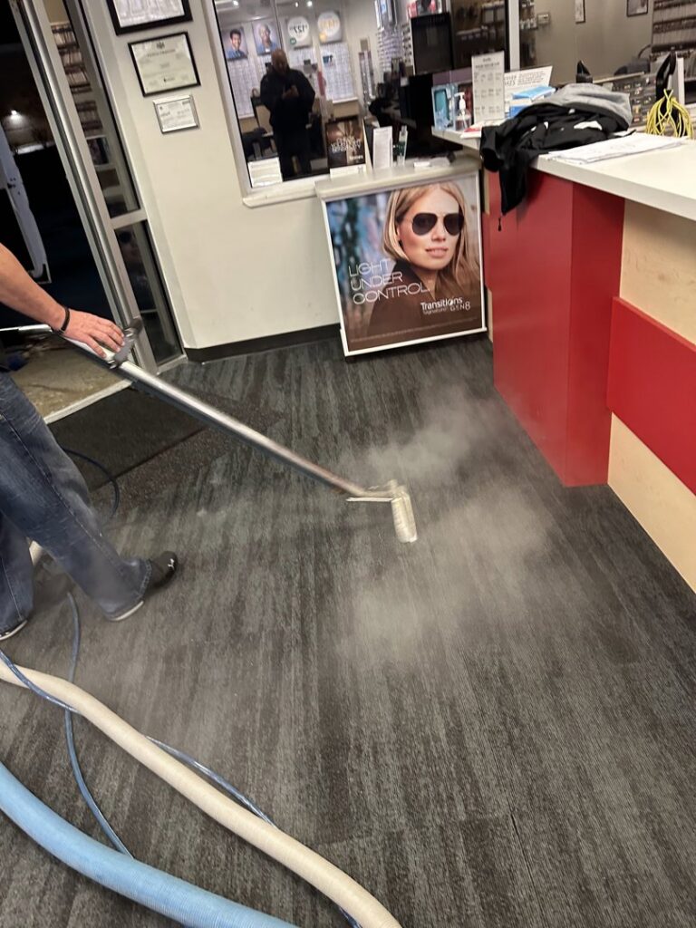 A professional performing steam carpet cleaning with a wand on commercial flooring for Super Duper Carpet & Duct Cleaning in Pittsburgh, PA.