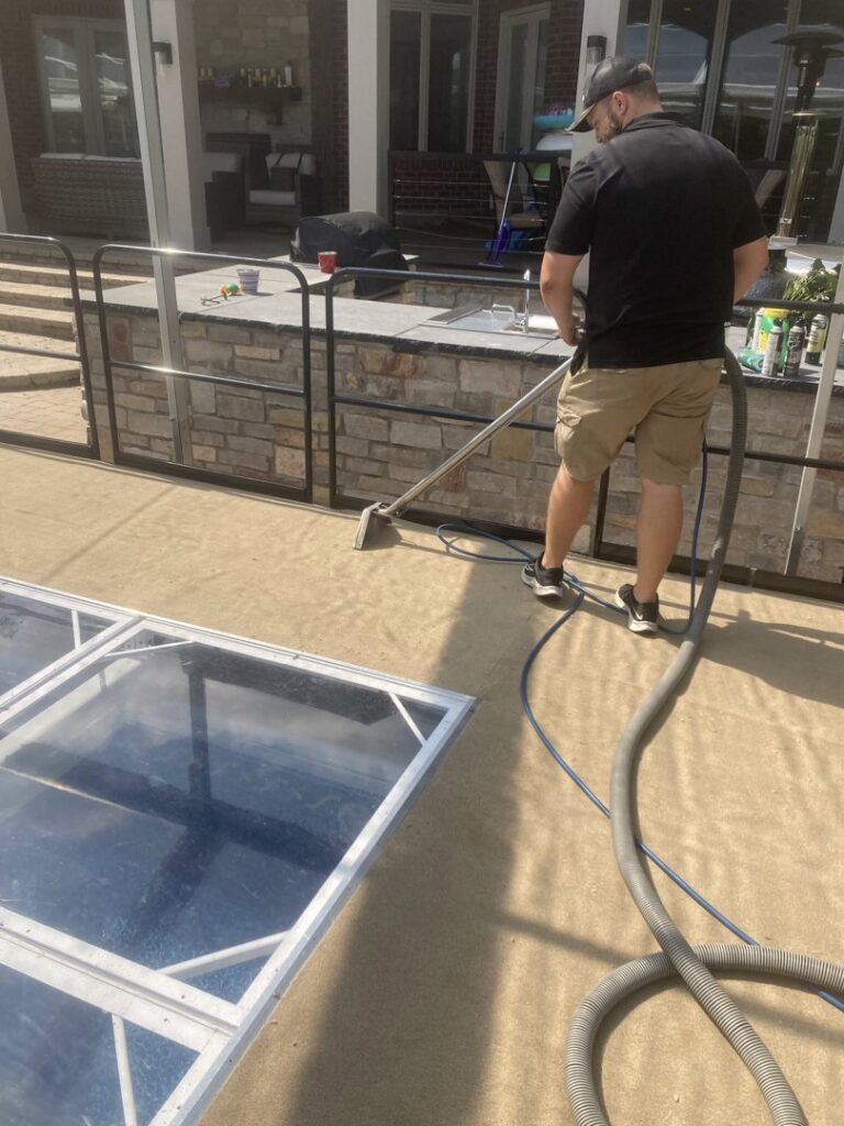 A professional from TCK Carpet Cleaning cleaning outdoor carpet or turf in Indianapolis, IN.