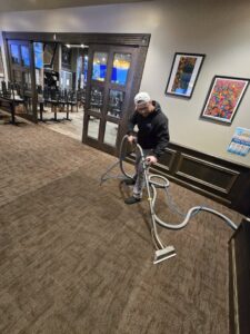 A professional performing commercial carpet cleaning with a machine by On The Spot Carpet and Upholstery Cleaning in Warren, MI.