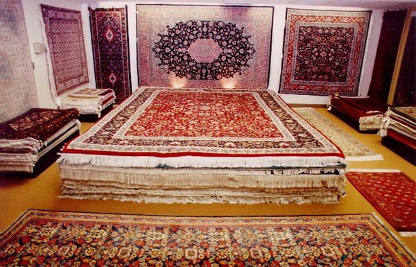 Workers performing professional oriental rug cleaning with specialized machines at Demanes Oriental Rugs in Peoria, IL