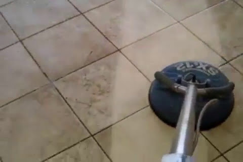 A professional tile cleaning machine actively cleaning a tiled floor, showing a clear before-and-after line, by A Copesetic Carpet, Upholstery, Tile & Grout Cleaner in Mesa, AZ