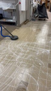 Professional tile floor cleaning in progress using a rotary scrubber by All American Carpet & Tile in San Diego, CA