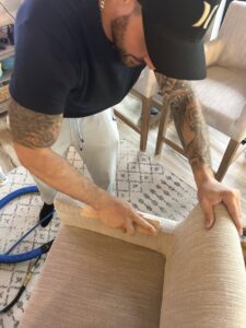 A professional cleaning an upholstered chair, demonstrating attention to detail by 5 Alarm Carpet Care in West Allis, WI.