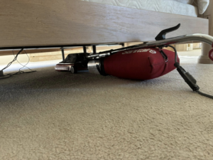 A professional vacuum cleaner reaching under a bed to clean carpet by Steamex Carpet Cleaning Phoenix, AZ.