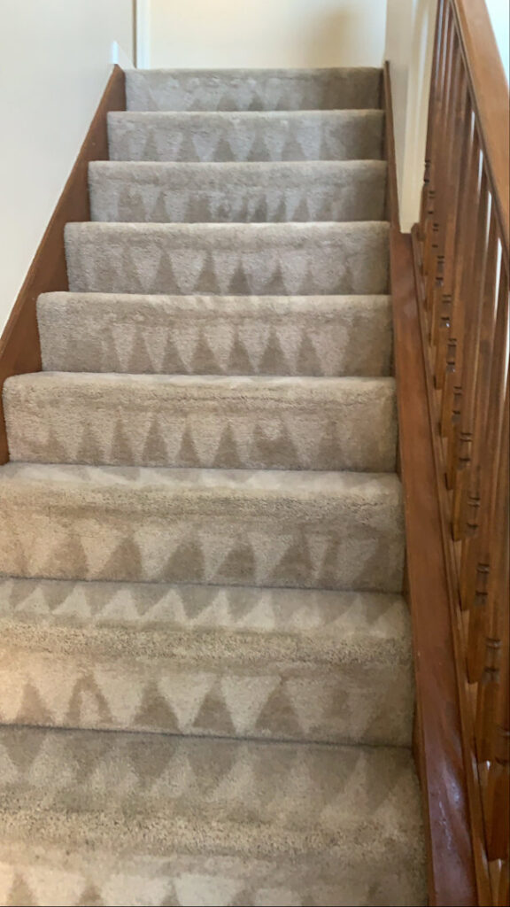 Professionally cleaned carpeted stairs showing fresh cleaning lines by Iclean Indy, a carpet contractor in Indianapolis, IN.