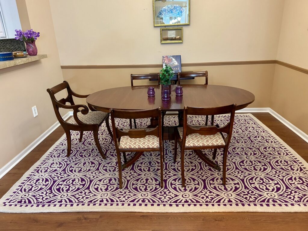 A beautiful purple and white patterned area rug enhancing a dining room, provided by Yas Rugs in Lexington, KY.