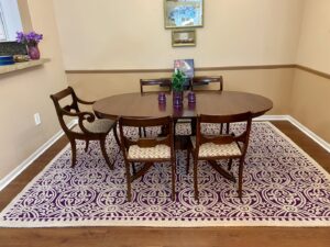 A beautiful purple and white patterned area rug enhancing a dining room, provided by Yas Rugs in Lexington, KY.