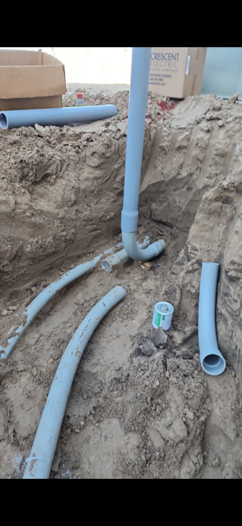 PVC electrical conduits laid in a trench during an underground wiring project by Island Electric in Grand Island, NE.