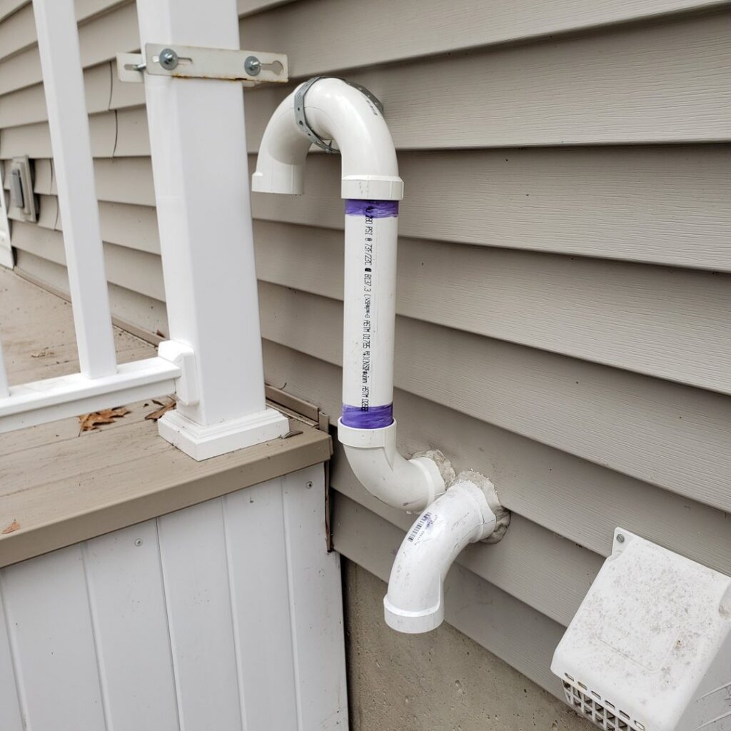 PVC exhaust piping installed on the side of a residential home by A-OK Heating & Cooling in Concord, GA.