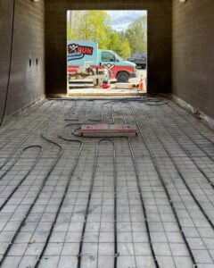 Radiant floor heating pipes being installed on a concrete slab by Home Run Mechanical in Ann Arbor, MI.