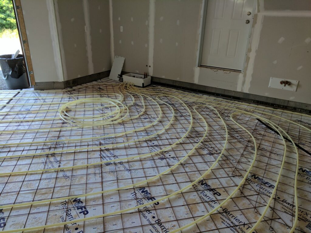 Radiant floor heating tubes laid out on a subfloor during installation by Huether Heating & Cooling Inc in Rochester, NY.
