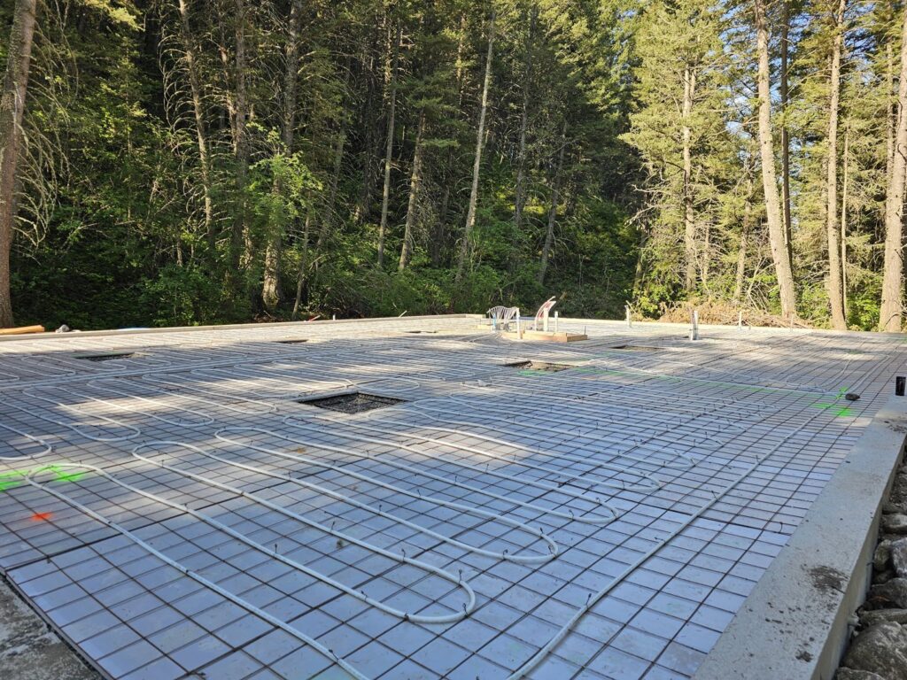 Radiant floor heating tubes laid out on a concrete slab during installation by Perfect Temp LLC in Bozeman, MT.