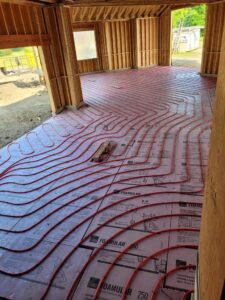 Radiant floor heating tubes being installed on insulation in a new construction project by Supreme Stands in Maple Grove, MN