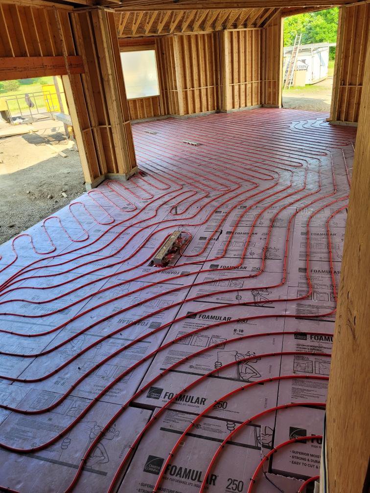 Radiant floor heating tubes being installed on insulation in a new construction project by Supreme Stands in Maple Grove, MN