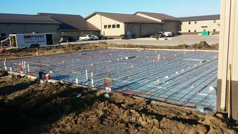 Radiant floor heating pipes laid out on insulation before a concrete pour by The Heating Guys in Fargo, ND.