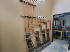 Copper piping and manifolds for a radiant floor heating system installed by Advantage Mechanical, Inc. in Appleton, WI.
