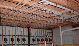 Radiant heating pipes installed on a ceiling or floor joists by Pugh Heating & Air Conditioning in Holland, OH.