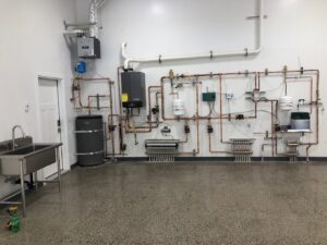 A comprehensive radiant heating system with boiler, water heater, and manifolds by Boiler Man Plumbing & Heating in Palmer, AK