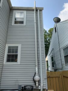 An exterior view of a newly installed radon mitigation system by Protect Environmental in Louisville, KY