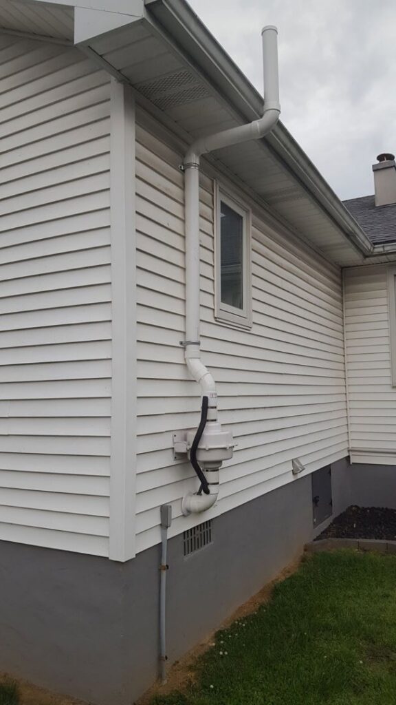 A radon mitigation system installed on the exterior of a residential home by Protect Environmental in Louisville, KY
