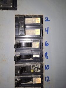 Close-up of a residential electrical panel showing breakers for range and stove, indicating service by Pro Circuit Electric in Peoria, IL.