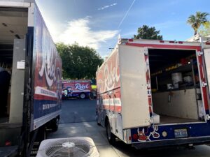 Rebel Refrigeration service trucks parked with an HVAC condenser unit in the foreground in Las Vegas, NV.