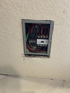 A recessed electrical control box with visible wiring installed by Sunrise Electric LLC in Kalispell, MT.