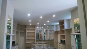 Newly installed recessed lighting and a chandelier in a modern room by Premo Electric in Spring Valley, CA