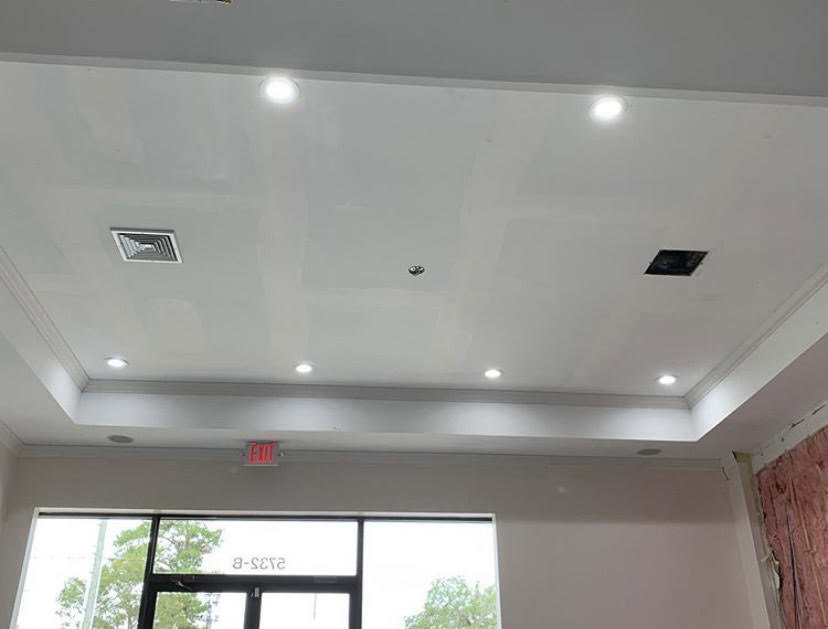 A commercial ceiling with multiple recessed lights and an exit sign, installed by Harbour Electric in Wilmington, NC.