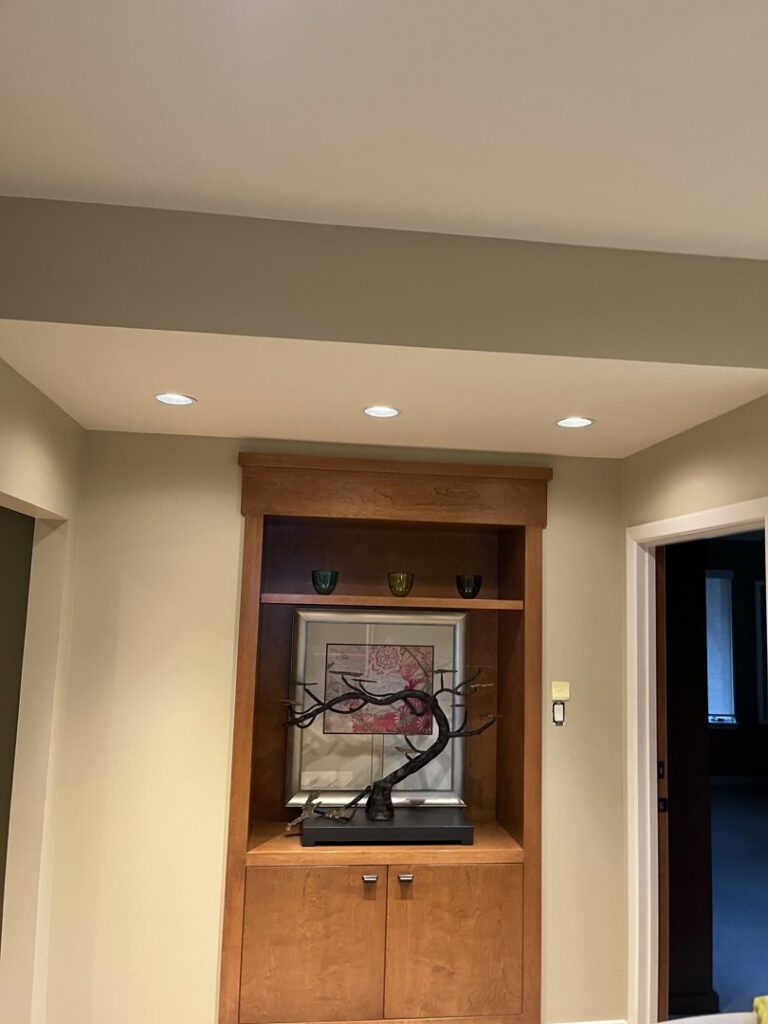 New recessed lighting installed in a ceiling above a built-in shelf by Innovate Electric in Earth City, MO.