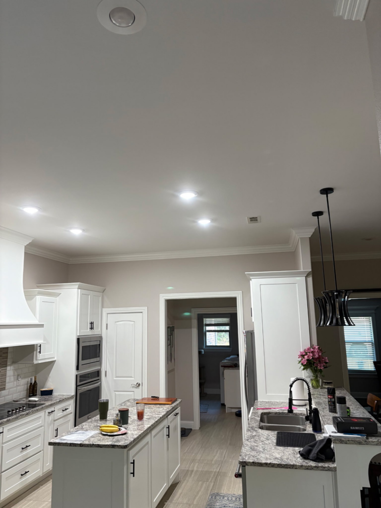 Bright recessed lighting and stylish pendant lights in a modern kitchen by 3E Enterprises, LLC in Washburn, MO.